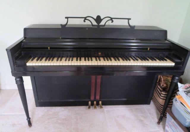 Black upright Wurlitzer piano and piano bench