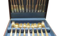 This set of 64 pieces (service for 12) consists of 12 dinner forks, 12 salad forks, 12 soup spoons, 12 knives, and 16 teaspoons. It is gold electro-plate over silverplate. It is in the original wooden box and is in perfect condition. It is Argosy by