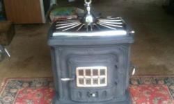Antique Cast Iron Parlor stove (wood) from the 30's era. Detachable base, 2 burners, 2 doors and large brass eagle on base. Can deliver for additional costs. ***** $100 Cash Today Only! *****