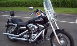 A REALLY NICE SUPER GLIDE CUSTOM!
This great looking bike has a detachable windshield, an engine guard, and a set of highway pegs for rider comfort. For the passenger there is a sissy bar with a luggage rack. And for sound, you have a set of Rush slip on