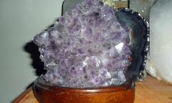 Amethyst Gemstone Light on a Wooden Base-This is a Beautiful Amethyst light, violet in color and with a on off switch on a brown wooden base. One of a kind, and come from Brazil. Measurements on base 6 1/2? Tall 6? Wide and 4 1/2? Thick, Base 7?x 5? This