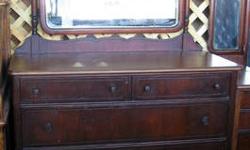 This is an undated Dresser with mirror in good condition. This has a few spots of missing veneer on the lower facia below the front draws and is a bit less than perfect. The top has also been stripped and re-finished. The curved edge mirror is 34"W x 28"T