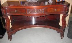 This is an antique 1940s Mahogany Vanity Desk with matching shield shaped mirror. It is in very good condition with some light wear on the top surface finish as well as some on the lower left legs. This comes with a matching Mahogany wall mirror. The