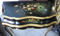 This an undated antique black lacquer painted vanity makeup table with folding top with mirror and compartments. Gold painted trim and ornate floral painting on lid and sides. The vanity is in very good condition.
Dimensions: 33" Wide x 16" Deep x 31"
