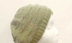 This knitted beanie beret hat is made with an acrylic and wool yarn. The color is a sage green. It is knitted in a pattern called ?tracks?. Medium thickness, very stretchy, will fit any head, will stretch out to 31 inches around. The measurements are