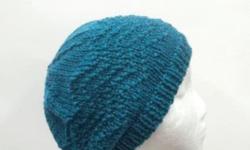 Original one of a kind beanie. Suitable for women,teens. This beanie hat is the color of turquoise or teal. A diagonal pattern is knitted into the hat. Completely hand knitted and is made with a nice soft acrylic yarn. Very stretchy, will fit any head,