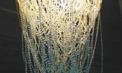 Hand made and custom designed chandelier previously used as high-end dÃ©cor for a couture space. This colossal chandelier features two circular, supportive metal frames that dangle a mixture of Swarovski, Austrian crystals and decorative gold chains. Each