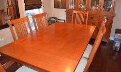 Beautiful Mission Style cherry dining set in excellent condition. Set includes table and china cabinet with 4 side chairs and 2 arm chairs. Table is 70" by 42" with two 12" leafs.