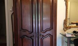 This stunning solid wood armoire is hand-carved with beautiful hardware. It provides lots of space for clothes, books, DVDs, etc.