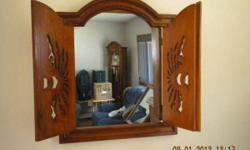 Beautiful Wood carved Mirror. Has doors that swing out / close. Dimensions are 24 inches wide / 28 inches tall