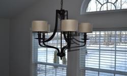 This is a dark oil rubbed bronze chandelier. It has 5 lights with 5 shades. The chain is adjustable at 37 inches in height. The overall width is 27 inches and the overall Height of fixture is 21 inches.