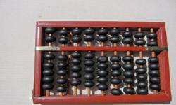 Chinese abacus in original box, 8 1/4" x 5", black with brass accents, has original directions for use, small crack on one side