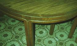 Wood. Table with leaf is approximately 3 feet x 5 feet. Without leaf, table is round. Four chairs, with off white cushions that are covered with plastic . Works in a kitchen or casual dining room. Two replacement cushions included.