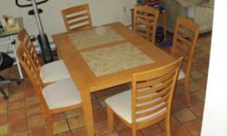 Large dining set in good condition. Light wood dining set with tile inlay, 12" leaf extension and six ladder back chairs. Lightly used. Size of table is 60" long by 40" wide. 72" long with leaf inserted.