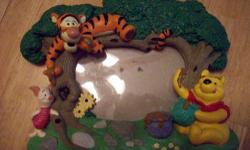 Cute resin picture frame, has sculpted 3D figures around frame of Winnie the Pooh, Tigger, and Piglet. This picture frame is in good used condition, does show some minor wear, but it is not that noticeable. Does not have any cracks or breaks. Stand in
