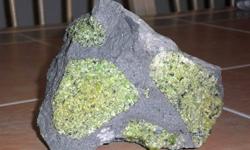 Gem Peridot in Balsalt-A large cabinet size Specimen Measurements 5 3/4" Wide, 4 3/4" High and 3 3/4" Thick. Weighing in 5 pounds! Peridot from the San Carlos Indian Reservation is among the finest in the world. You are looking at a very impressive mass