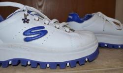 These white Skechers are new and unworn. There are blue details, charm details and sparkly silver stitching detail.