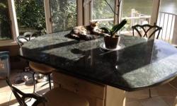 For sale is a green granite kitchen table or island.
The granite is a lovely symmetrical oval shaped which measures 66" x 46" at the longest points.
The table is supported by a unique cabinet which has a rolling serving shelf bar drawer.
The table is