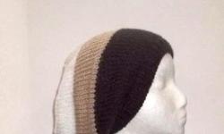 The colors in this hand knit oversized slouchy beanie hat are dark brown, tan, and white, this oversized hat is made with a soft an acrylic yarn, knitted in large stripes, large size. Completely hand knitted. Worn by men and women. It is a medium