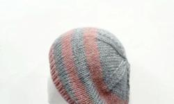This hand knitted beanie hat is made with a soft wool and acrylic yarns. The stripes are pink and gray. This beanie is a medium thickness, very stretchy, will fit any head, stetches out to 31 inches around. The measurements are lying flat on a table,