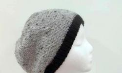 This knitted beanie is medium grey with tiny flecks of black and light brown worked into the yarn. Completely hand knitted with a black brim. Suitable for men and women. A warm slouchy beanie hat. Will fit any head, stretches out to 31 inches around. The