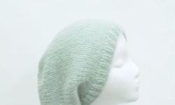 The color of this knitted slouch hat is a beautiful pale sea foam color. This oversized beanie is made with a soft acrylic, mohair and wool blended yarn. It is described as a soft fuzzy warm hat. The measurements are lying flat on a table are across the