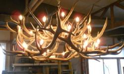 Masterly crafted by a local Adirondack artisan, this real elk horn chandelier measures approx. 60" in diameter and 30" in height with (40) 25w candelabra lights. Stunning when lit, this chandelier would be a beautiful addition to any rustic decor, lodge,
