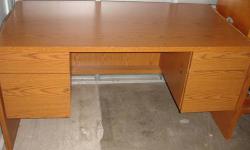 Large and very heavy oak finish desk with rounded ends and lots of leg room. The top is perfectly flat and smooth and a pleasure to use. It has two small top drawers on each side above two file drawers that open and close very easily, and can be locked.