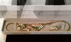 This designer signed LUSTERN (Louis Stern), circa early 1940's gold tone necklace and matching clip on earrings. The necklace measures 15" long, earrings measure 1" long. All three pieces are set with clean, white crystals and emerald green baguette