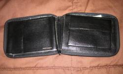 Shown are two pictures of a fine Prince Gardner leather wallet, which zips, has several compartments, including room for paper money as well as a separate compartment for change. It has two small initials on the front bottom right corner and costs $25.