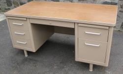 Metal tanker desk built in the 1950s or 1960s. In really good condition. Recently painted by a professional. Tan color, wood grain pattern top, rounded edges, and slim line draw pulls make it a real conversation piece. Double pedestal so it has plenty of