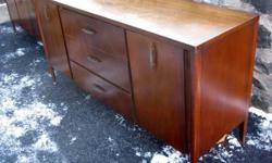 Manufactured by Broyhill Premier in 1960 as part of their Cerama collection. The slender, tapered lines emphasize the mid-century design. Has three drawers and two cabinets with shelves. Brass handles and ball feet on front legs. Needs minor repair.