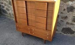 Very attractive highboy dresser with inlaid rosewood. Sleek Danish design with modern lines and elegant legs. Made by Thomasville in the 1960s as part of their Motif collection. Plenty of storage with 6 drawers, and 4 drawers behind the cabinet doors. In