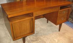 This desk has a very smart, mid-century design and very well made. Its finished on both sides so it can be placed in the middle of the room. Note the cane detail and floating top. Made of American walnut. Its in really good condition. Glass has protected