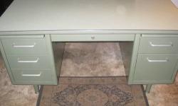 This double pedestal tanker desk is in really good condition. Its a pale green desk with an original Formica top with no scratches. It has rounded edges, slim line draw pulls, and plenty of drawers. Its a piece of Americana that?s very cool. This metal