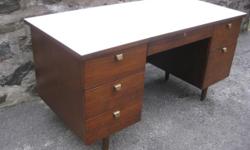 Here?s a simple, but very stylish mid-century modern desk, circa 1960s. Notice the smart metal drawer pulls, the tapered legs, and the durable laminate top. Measures 26 Ã 56 Ã 29 high. Plenty of storage space. In good vintage condition. The white top is