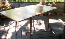 This is a very unique table with its sleek design. I was told its from the 1950s, but doesn't have the aluminum trim around the table top like most. The sides are black with angles and it tapers. The top is made of wood with a yellow laminate. The yellow