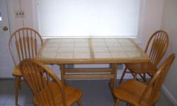 Oak dining table with expandable insert, inlaid with ceramic tile. Comes with 4 chairs. Moving so make offer.
