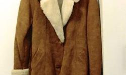 Summer's over. Autumn in new york may bring glittering crowds and shimmering clouds in canyons of steel--but it also brings nippy days and cold windy nights.
Treat yourself to this stylish short coat of burnt orange shearling trimmed by white fur cuffs