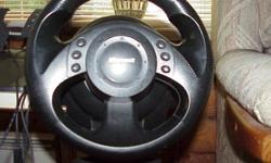 Steering wheel mounts to table top with adjustable clamp, has 6 top thumb buttons and 2 under the wheel, all programmable for those driving shoot-em up type of games. Made by MicroSoft. Comes with 2 foot pedal floor controls for gas and brake controls or