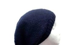 This hand knit slouch beanie is a dark navy blue. This beret is made with a soft acrylic yarn. Medium thickness, very stretchy, will fit any head, stretches out to 31 inches around. The measurements are laying flat on a table. Across the brim or ribbing =