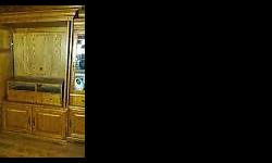Solid Oak TV Armoire Entertainment Center with two side display cases with lighting. Very good condition. Price is negotiable.
