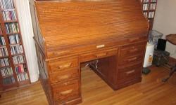 Solid oak roll-top desk measures 36" deep, 60" wide, 54" high. Winner's Only brand. In great condition. Hanging file drawer on left side, dividers in top 2 drawers, Cabinet on right will hold printer or computer. Black blotter pad was added and is