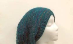 This hand knit slouch hat beanie is a beautiful teal (turquoise) with multicolor stripes that has a little sparkle in the multicolor stripes. This slouch hat is made with a mohair yarn, acrylic yarn and silk yarn. Medium thickness, very stretchy, will fit