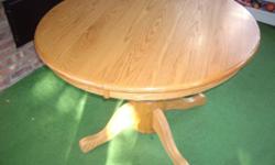 This used oak kitchen/dining table is 41 1/2" round table. With the 18" extension it becomes 41 1/2" by 59 1/2" oblong table. It has some marks, but overall in very good condition. Note: There is no chairs just the table.