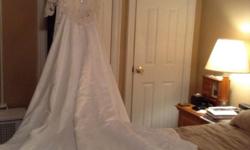 Selling my vintage lace wedding dress with long train. Purchased new and worn only once in July 2010. Has been cleaned and preserved. Off the shoulder, long sleeved, v-neck, straight line white dress with slit in the back and detachable long train.