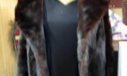 This is a beautiful vintage Ladies Mink Fur Coat. Exquisite and timeless feel and look. Made or distributed by Lewis Brothers Furs, Brooklyn, NY as labeled. A very nice Dark Maroon Color with hints of other colors as it reflects light. Fur is tight and