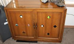 This is solid Maple cabinet and it needs a new home. It is over 50 years old and very solid . It has cloverleaf cut outs as you can see on the door panels. Really a retro piece. Very heavy piece