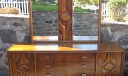 This beautiful dresser is rare piece from the 1970s. Beautiful design with brutalist accents. Plenty of storage too. In very good condition. Made in Canada of walnut wood. No information on the manufacturer. Mirror optional. Without the mirror, it an be
