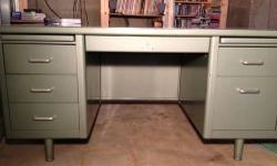 This double pedestal desk is in really good condition. Its painted pale green with a lighter green Formica top. It has rounded edges, slim line draw pulls, and plenty of drawers. Its a piece of Americana that's very cool. This metal desk would look great
